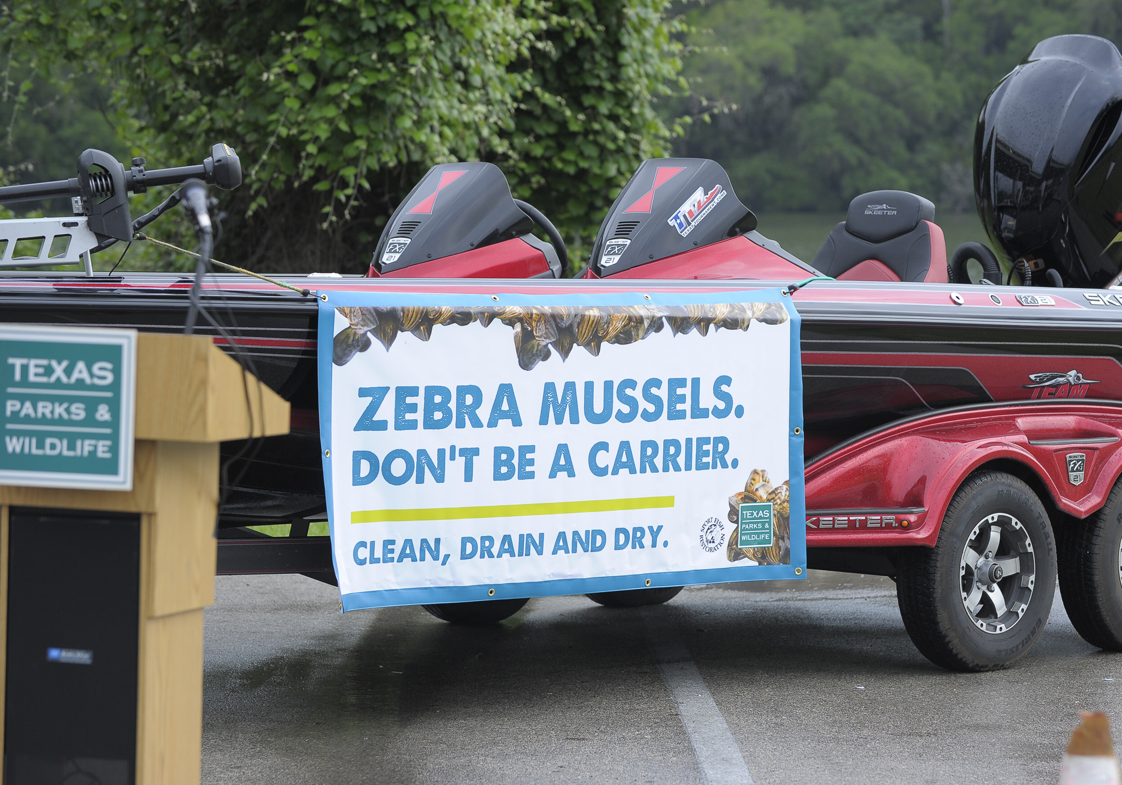 Boat with sign that reads zebra mussels, don't be a carrier. Clean, Drain and Dry.